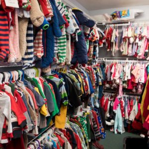 children's clothes hanging on many racks